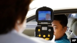FILE - A South Korean official, left, uses a thermal camera to checks the body temperature of a driver as a precaution against Middle East Respiratory Syndrome (MERS) after he returned from Kaesong, North Korea, near Panmunjom, South Korea, June 13, 2015.
