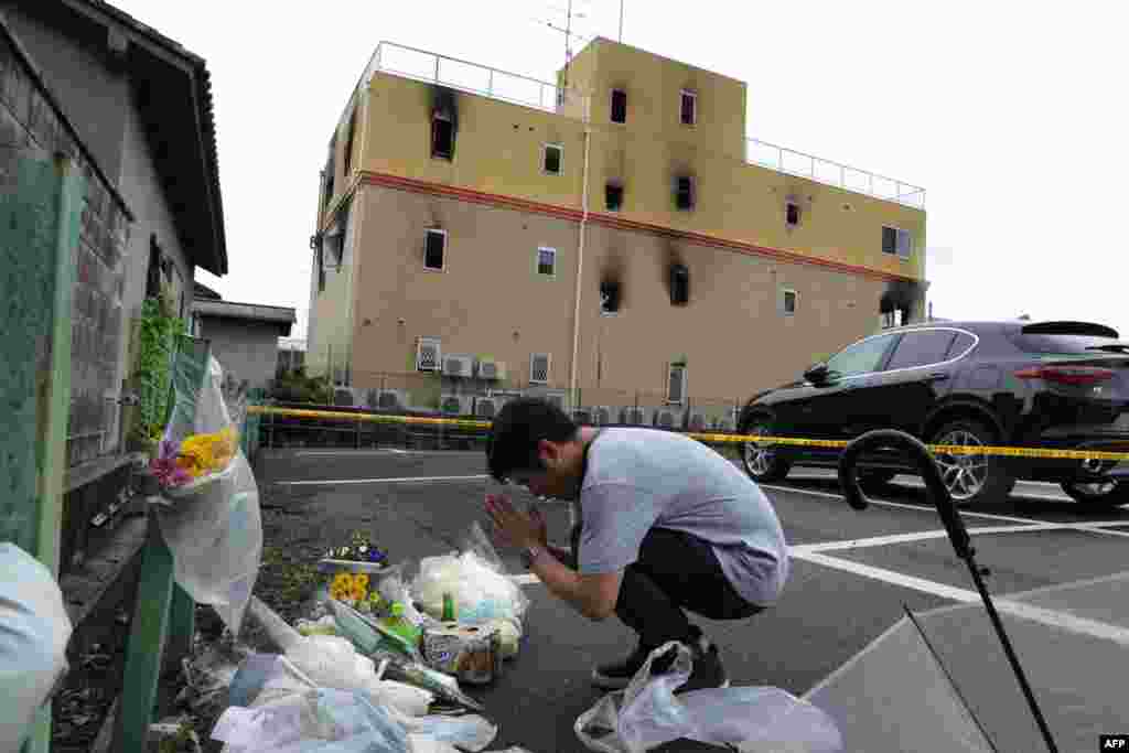 A man prays next to flowers and tributes laid at the scene where more than 33 people died&nbsp; and scores injured in a suspected arson attack on an animation company building in Kyoto, Japan.