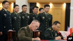 美军参联会主席邓福德上将（前左）与中国中央军委联合参谋部参谋长房峰辉在北京签署协议。 （2017年8月15日）