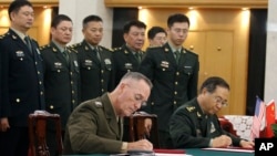 美军参联会主席邓福德上将（前左）与中国中央军委联合参谋部参谋长房峰辉在北京签署协议。 （2017年8月15日）