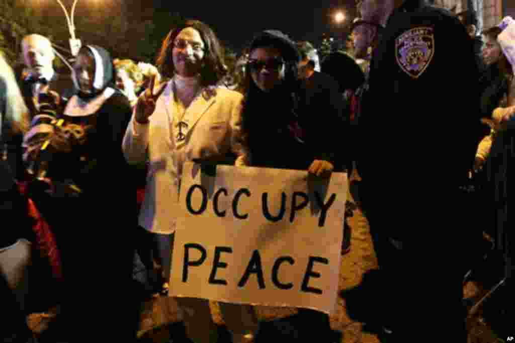 Ричи Есквичи престорен во Џон Ленон, со слоган „Окупирај го мирот“ за време на парадата. (AP Photo/Tina Fineberg)