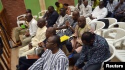 FILE - Luc Adolphe Tiao, the last prime minister of the former leader of Burkina Faso, Blaise Compaore, sits with other officials during the first day of their trial at the justice palace, in Ouagadougou, Burkina Faso, April 27, 2017. 