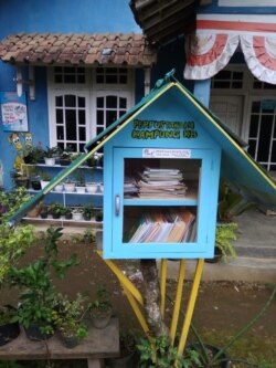 Little Free Library di Desa Jolontoro, Wonosobo berdiri sejak September 2020 di depan sebuah rumah warga dengan cat senada. Courtesy Nining Dwi Astuti.