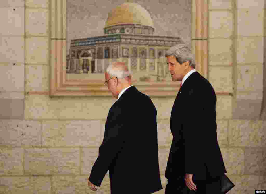 U.S. Secretary of State John Kerry walks with Palestinian Chief Negotiator Saeb Erekat upon his arrival in the West Bank city of Ramallah, May 23, 2013.