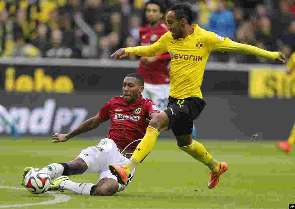 Pierre-Emerick Aubameyang du Dortmund, originaire du Gabon (à droite) se disputent un ballon avec Marcelo de Hanovre du Brésil (à gauche) &nbsp;lors du match de football de la première division de Bundesliga (Allemagne) entre le Borussia Dortmund et BvB Hannover 96 à Dortmund, Allemagne, le samedi 25 octobre 2014. 