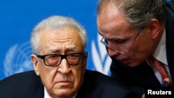 U.N.-Arab League envoy for Syria Lakhdar Brahimi (L) listens to his adviser Moncef Khane before a news conference at the United Nations European headquarters in Geneva, Feb. 11, 2014.