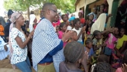 Relatives and friends welcome back Wisconsin politician Samba Baldeh, in checkered cloth, during a visit to his home village of Choya, Gambia, in August 2021.