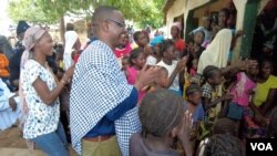 Relatives and friends welcome back Wisconsin politician Samba Baldeh, in checkered cloth, during a visit to his home village of Choya, Gambia, in August 2021.