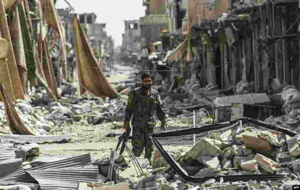 A member of the Syrian Democratic Forces (SDF) walks through the debris in the old city center on the eastern frontline of Raqqa.