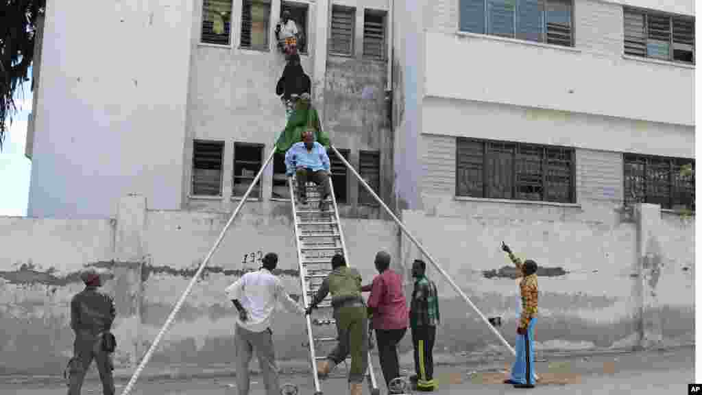 Survivors are helped to escape from a window at Mogadishu’s court complex in Mogadishu, Somalia, April 14, 2013.