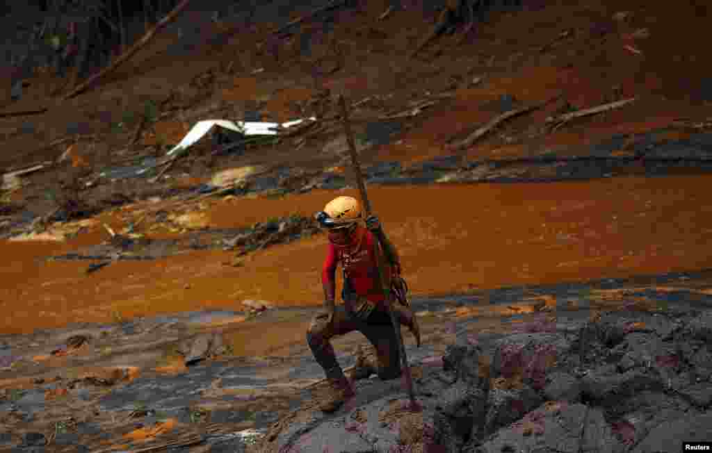 A rescue worker searches for victims at Bento Rodrigues district that was covered with mud after a dam owned by Vale SA and BHP Billiton Ltd burst, in Mariana, Brazil, Nov. 8, 2015. 