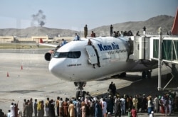 Warga Afghanistan yang panik dan ingin meninggalkan negaranya, naik ke atas badan pesawat di bandara internasional Kabul (foto: dok).