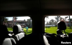 FILE - A United States Secret Service agent is seen from a press van at President Donald Trump's Mar-a-Lago estate in Palm Beach, Florida.