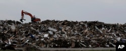 An excavator is used to move a mountain of debris created in the wake of Hurricane Harvey, Port Aransas, Texas, Sept. 29, 2017.