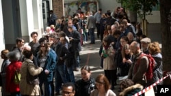 People line up before casting their vote for the first-round presidential election at a polling station in Paris, April 23, 2017. 