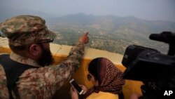 A Pakistan army officer points out the Indian forward area posts to journalists at Bagsar post on the Line of Control that divides Kashmir between Pakistan and India, on October 1, 2016. According to a report, Prime Minister Nawaz Sharif urged spy chief R