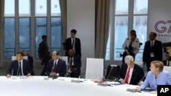 Desde la izquierda, el presidente francés Emmanuel Macron, el presidente egipcio y presidente de la Unión Africana, Abdel Fattah al-Sissi, el presidente de Chile, Sebastián Pinera, y la canciller alemana, Angela Merkel, asisten a una sesión de trabajo centrada en el clima en Biarritz, suroeste de Francia, el lunes 26 de agosto de 2019, en el tercer día de la Cumbre anual del G7. El asiento vacío era el lugar reservado para el presidente Donald Trump.