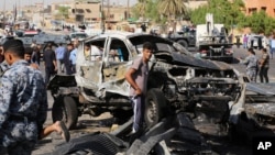FILE - Civilians and security forces inspect the site of a car bomb explosion in the southeastern neighborhood of New Baghdad, Iraq, Wednesday, Sept. 10, 2014. 