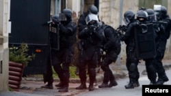 Tim polisi khusus melakukan pencarian dari rumah ke rumah di Longpont, timur laut Paris (8/1).