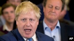 FILE - With then-British Prime Minister David Cameron in the background, Boris Johnson, then London's mayor, speaks at a campaign rally for a Conservative mayoral candidate in London, May 3, 2016. Johnson is new PM Theresa May's pick to be foreign minister.