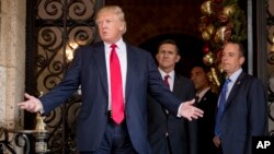 President-elect Donald Trump, left, accompanied by Trump Chief of Staff Reince Priebus, right, and Retired Gen. Michael Flynn, a senior adviser to Trump, center, speaks to members of the media at Mar-a-Lago, in Palm Beach, Fla., Dec. 21, 2016. 