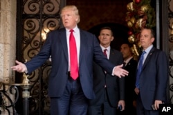 FILE - Then-President-elect Donald Trump, accompanied by Reince Priebus, right, and Michael Flynn, center, speaks to reporters at Mar-a-Lago, in Palm Beach, Fla., Dec. 21, 2016.