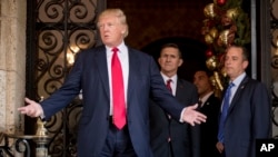 FILE - President-elect Donald Trump, left, accompanied by Trump Chief of Staff Reince Priebus, right, and Retired Gen. Michael Flynn, a senior adviser to Trump, center, speaks to members of the media at Mar-a-Lago, in Palm Beach, Florida, Dec. 21, 2016.