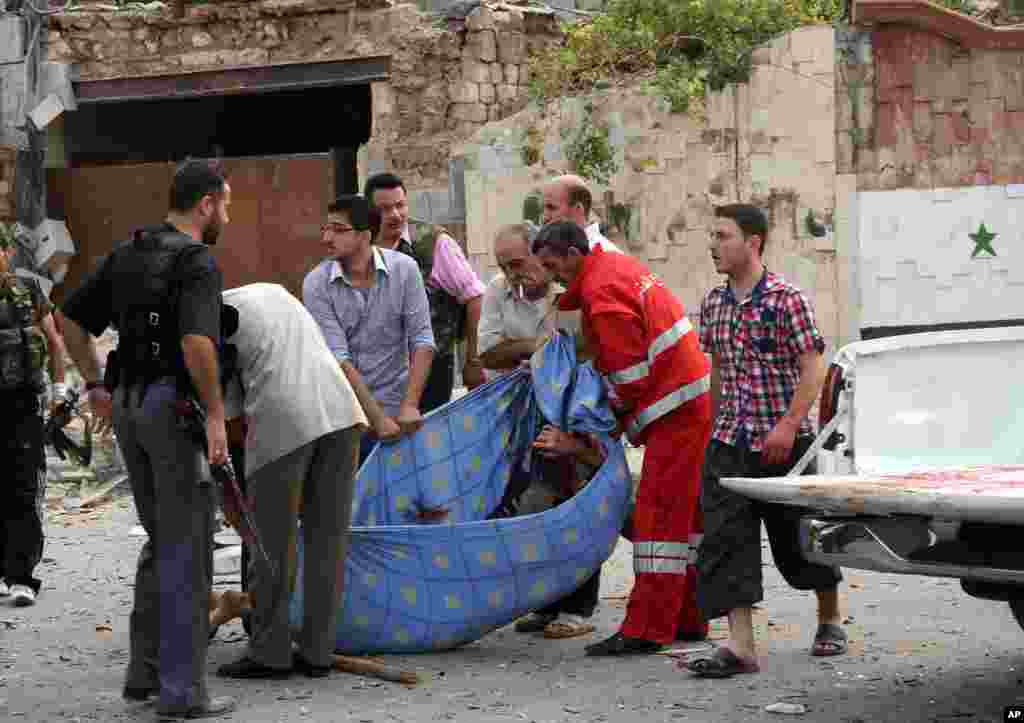 This photo by the Syrian official news agency SANA shows Syrian men carrying a body after bombs bombs exploded in Saadallah al-Jabri square, in Aleppo, Syria, October 3, 2012.