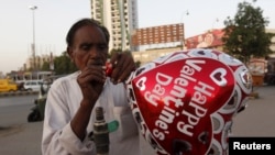 A vendor inflates a heart-shaped balloon from his cart ahead of Valentine's Day along a road in Karachi, Pakistan in this picture taken Feb. 10, 2016. 