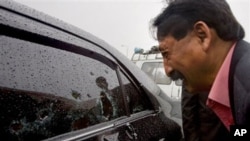 Wasif Ali Khan, a friend of Pakistan's government minister for religious minorities Shahbaz Bhatti looks at the bullet-riddled window of car while he mourns over his death, Islamabad, Pakistan, March 2, 2011.