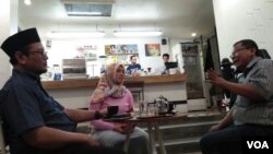 Nur Wulan (tengah) dan Widi Kamidi (kanan) warga Surabaya dalam obrolan warung kopi terkait tragedi di kota mereka. (Foto: VOA/Nurhadi)