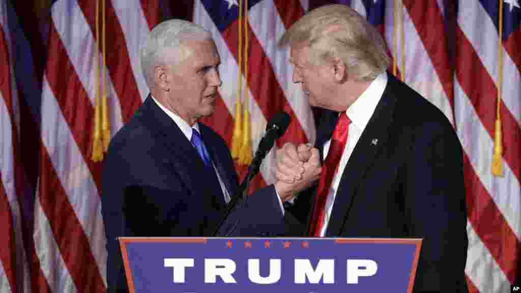 Le président élu Donald Trump se serre la main avec le vice-président élu Mike Pence au moment du discours d'acceptation au cours de la nuit électorale, à New York, 9 novembre 2016. 