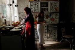 Ibu tunggal Irak Marwa Raed Taha, menyiapkan makanan bersama putrinya selama bulan Ramadhan di rumahnya, di Baghdad, Irak, 9 Mei 2021. (Foto: REUTERS/Saba Kareem)