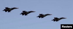 FILE - Russian Air Force Su-34 fighter-bombers take part in a military parade during celebrations marking Independence Day in Minsk.