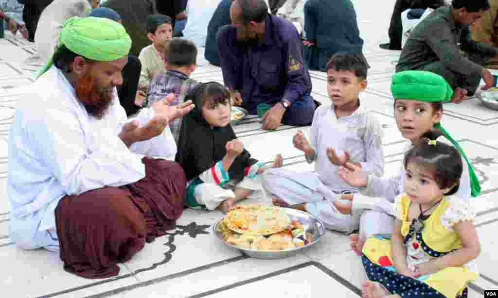 افطار سے قبل دعا مانگتے ہوئے ایک بزرگ اور کچھ بچے