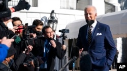 President Joe Biden talks to reporters before boarding Marine One on the South Lawn of the White House, Jan. 11, 2022, in Washington.