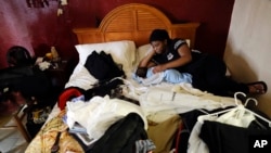 Jamica Batts sits on a hotel bed with her two-month-old baby Jarasiah Batts as they pack to leave on Sept. 4, 2017, in Houston. Batts and her brother Alvin may now be forced to go from the hotel they have been staying in after Hurricane Harvey, to an area shelter.
