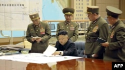 North Korea's official Korean Central News Agency on March 29, 2013 shows, according to KCNA, North Korean leader Kim Jong Un discussing the strike plan with North Korean officers during an urgent operation meeting at the Supreme Command in an undisclosed location. (Courtesy - AFP Photo/KCNA VIA KNS)