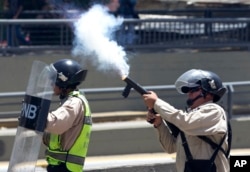 A Bolivarian National Police officer fires tear gas toward demonstrators during a protest in Caracas, Venezuela, April 8, 2017.