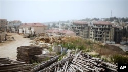Piles of building materials are placed on the ground at a construction site for a housing project in the West Bank Jewish settlement of Ariel, 26 Sep 2010