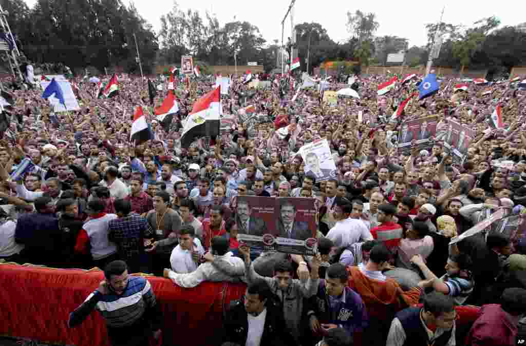 Supporters of Egyptian President Mohamed Morsi chant slogans and wave his campaign posters outside the presidential palace in Cairo, Egypt, November 23, 2012.