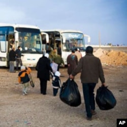 Palestinian refugees head towards the buses that will take them to Syria after years in Al Tanf refugee camp between the borders of Syria and Iraqi, Feb 2010