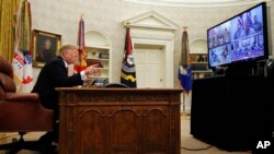 President Donald Trump greets members of the five branches of the military by video conference on Christmas Day, Dec. 25, 2018, in the Oval Office of the White House.