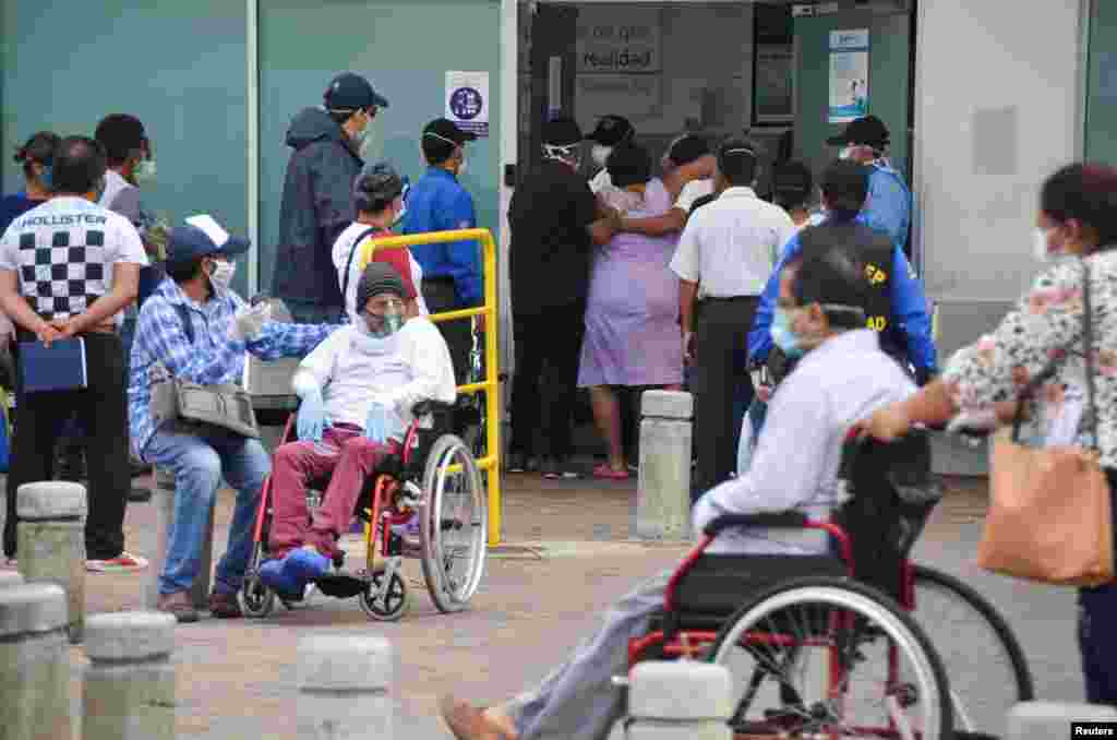 Una persona ayuda a una mujer a ingresar a la sala de emergencias del Hospital General Guasmo Sur después de que Ecuador informó sobre nuevos casos de la COVID-19, en Guayaquil, Ecuador, 1 de abril de 2020.