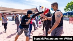 People practice MuayThai with a group of professional MuayThai instructors during a Free Self Defense Muay Thai Class, a martial art training against Asian hate crimes at Wat Thai Los Angeles, April 15, 2021. 