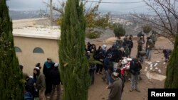 Jewish settlers gather around a synagogue in Amona, an unauthorized Israeli outpost in the West Bank, east of the Palestinian town of Ramallah, Sunday, Dec. 18, 2016. 