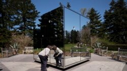 A woman peers into the sculpture "Infiniti Mirrored Room - Illusion Inside the Heart" by Japanese artist Yayoi Kusama at the New York Botanical Garden, Thursday, April 8, 2021 in the Bronx borough of New York.