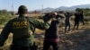 Agente de la .Patrulla fronteriza guía a los migrantes para que sean procesados tras intentar cruzar la frontera desde México hacia Sunland Park, Nuevo México, EE. UU., el 17 de septiembre de 2021.