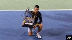 Novak Djokovic dari Serbia dengan piala Kejuaraan Dubai (2/3). (AP/Regi Varghese)