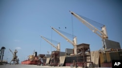 FILE - Cargo ship and oil tanker ship are idle at the port of Hodeida, Yemen, Sept. 29, 2018.